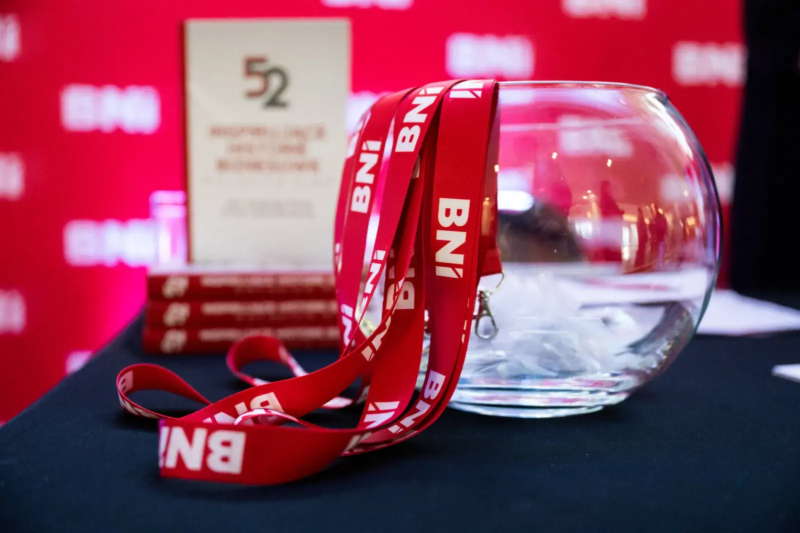 The book “52 historie” and BNI lanyards on a table