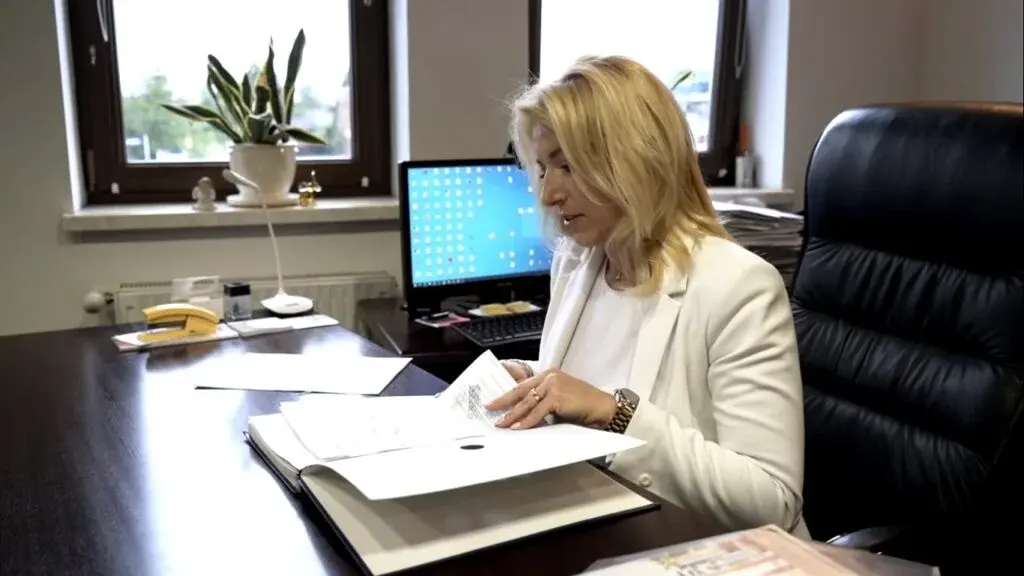 Barbara Huzarewicz przy biurku nad dokumentami
