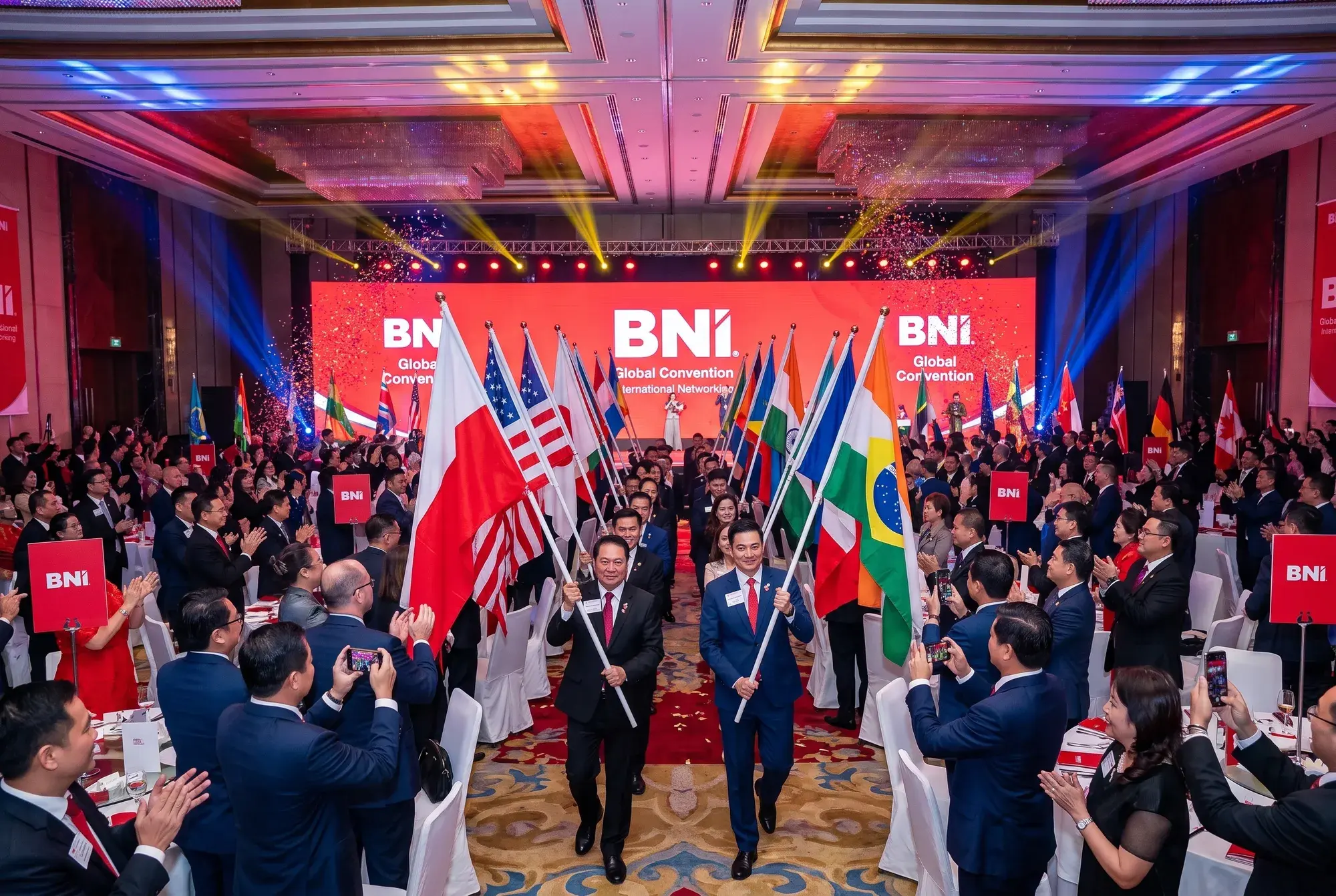 A BNI convention hall with the flags of many countries and a stage with the BNI logo