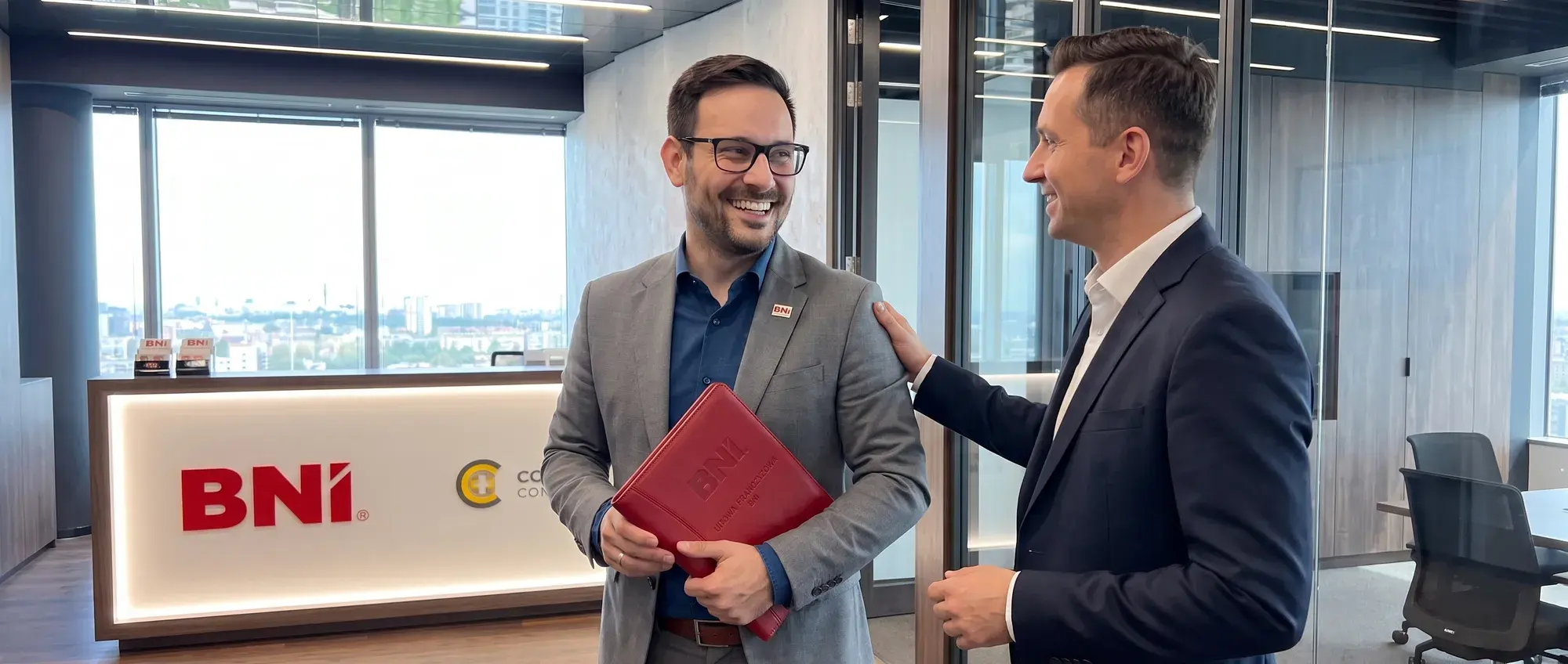A BNI Director with a red folder talks with a Member in the office