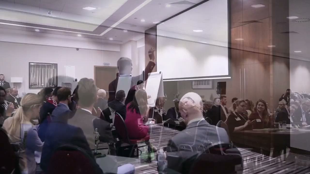 A BNI training room: participants at tables, the trainer at a flipchart