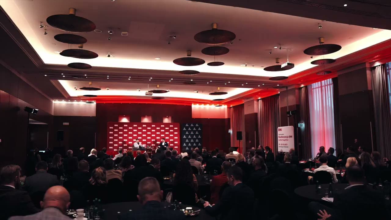 BNI Conference 2023: a full room and a conversation on stage in front of the BNI backdrop