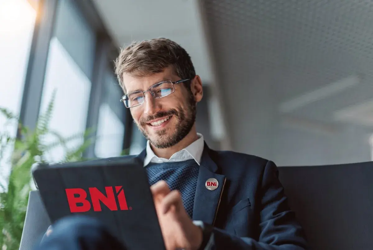 A business owner reading BNI materials on a tablet
